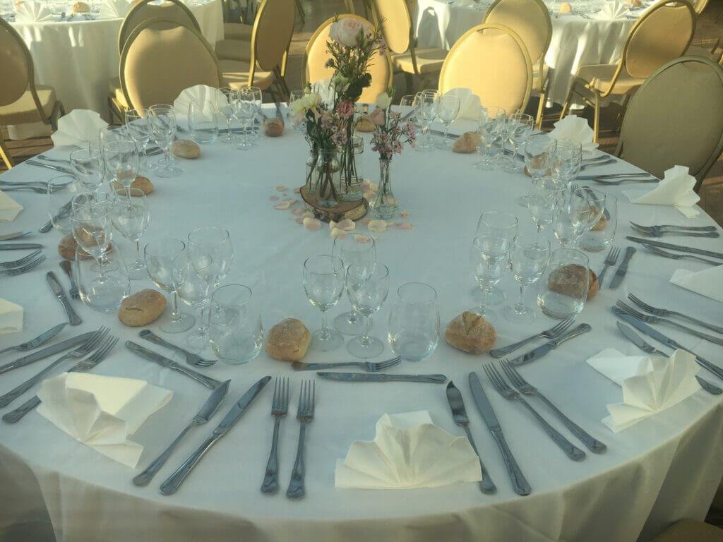 able de réception élégamment dressée par Metsouyane Traiteur sur le Bassin d’Arcachon, avec nappes blanches, verres, couverts, petits pains et décoration florale pour mariage ou événement casher.